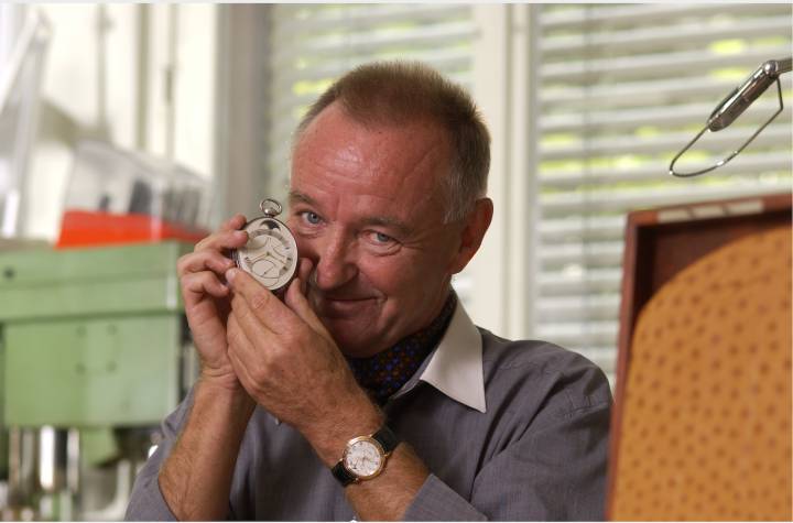Peter Baumberger sosteniendo su reloj Urban Jürgensen favorito, el reloj de bolsillo ovalado tourbillon de 1991, y llevando un Ref. 3)
