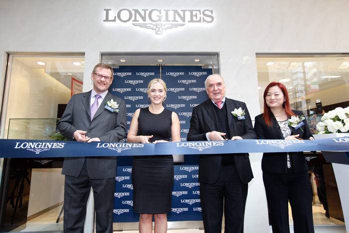 Ms. Kate Winslet inaugurando la Longines Flagship Store en Lockhart Road. Kate Winslet corta la cinta con Mr. Kevin Rollenhagen, Gerente del Swatch Group Hong Kong, Mr. Walter von Känel, Presidente de Longines, y Ms. Karen Au Yeung, Vice Presidenta de Longines Hong Kong (de izquierda a derecha).