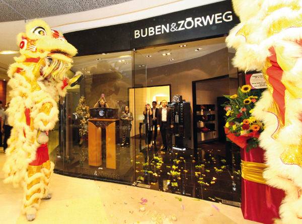 Los dos leones danzantes, acompañados por platillos y timbales, salen al encuentro de los propietarios de la Boutique de Buben & Zörweg para desterrar con toda ceremónia a los espíritus malignos de acuerdo con la tradición China