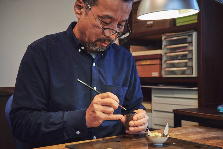 Nobuichi Otake trabajando en una esfera utilizando la técnica raden, que combina incrustaciones de conchas trituradas con laca urushi.