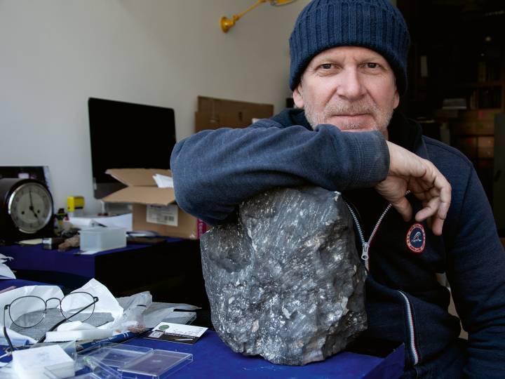 Luc Labenne con el meteorito Ghadames, una pieza orientada de 24 kg con marcas de impacto. (Foto Buonomo & Cometti)