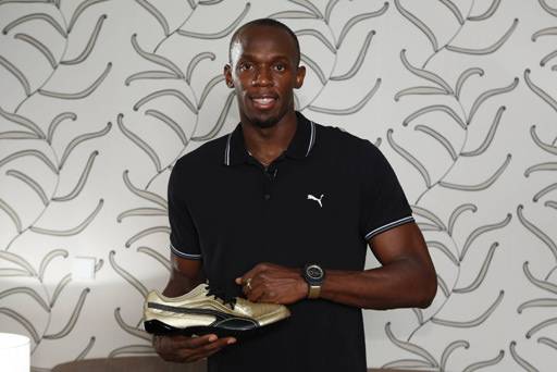 Usain Bolt mostrando sus zapatillas deportivas y la correa del reloj