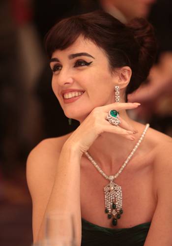 La actriz española Paz Vega interpreta el papel de María Callas. Ella lleva creaciones Cartier contemporáneas: un collar de platino de perlas, diamantes y esmeraldas; pendientes de oro blanco de diamantes, ónix y esmeraldas; un anillo Panthère en esmeraldas, ónice y diamantes, y una pulsera de diamantes en oro blanco.