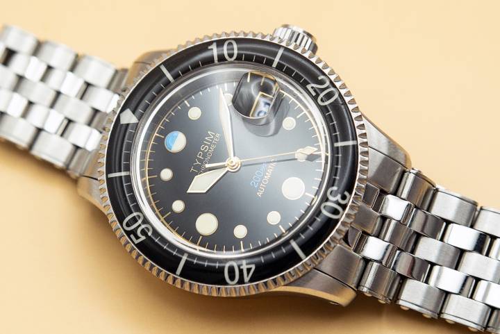 Los relojes Typsim 200M-C son cronómetros con la Tête de Vipère, probados y certificados en la histórica capital relojera de Francia, Besançon, en el Observatorio de Besançon. Antes de eso, cada reloj completo se prueba y ajusta rigurosamente en el taller de la marca en Seattle. Esfera dorada con revestimiento galvánico y relieve negativo. Cristal acrílico óptico abombado. Calibre Sellita SW300-1. 1.799.$