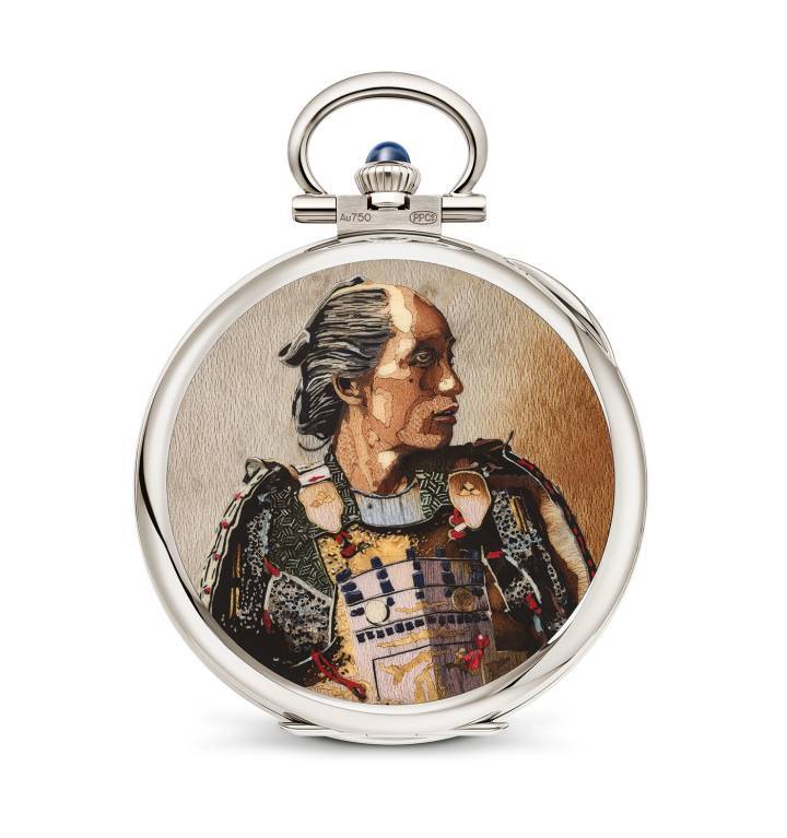 Este reloj de bolsillo “Retrato de un samurái” (995/131G-001) se encuentra entre los relojes excepcionales creados para esta gran exposición. Destaca por ser una de las decoraciones en marquetería de madera más complejas jamás creadas por Patek Philippe. El artesano de la marquetería cortó y ensambló la increíble cantidad de 800 chapas y 200 pequeñas incrustaciones que abarcan una paleta de 53 especies de madera en una multitud de colores, texturas y vetas.